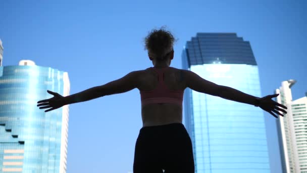 Motivierend inspirierende sportliche Frau, die in der Stadt die Arme in den Himmel reckt — Stockvideo