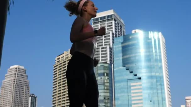都市スポーツの概念。市内の公園でジョギング若いスポーツ女性。スローモーション. — ストック動画
