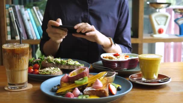 Technologie, sociální média a potravinové trendy. Fotografování potravin v restauraci. — Stock video