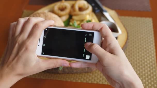 Primo piano mani di donna cibo blogger scattare foto di vegan hamburger con telefono — Video Stock