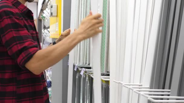 Joven hombre elegir zócalo de compras en la tienda de hardware — Vídeo de stock