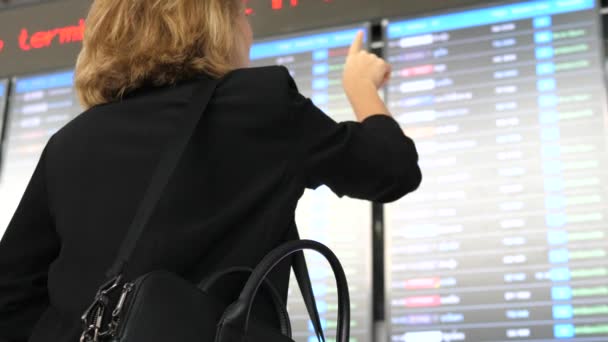 Mulher de negócios com bagagem no aeroporto Olhando para a informação Timetable Board — Vídeo de Stock