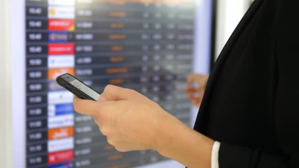 Hand van het bedrijfsleven vrouw met behulp van mobiele telefoon Controleren van de dienstregeling op de luchthaven — Stockvideo