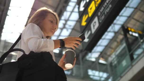 Passeggero viaggiatore d'affari donna che indossa Smartwatch in aeroporto utilizzando Smartphone — Video Stock