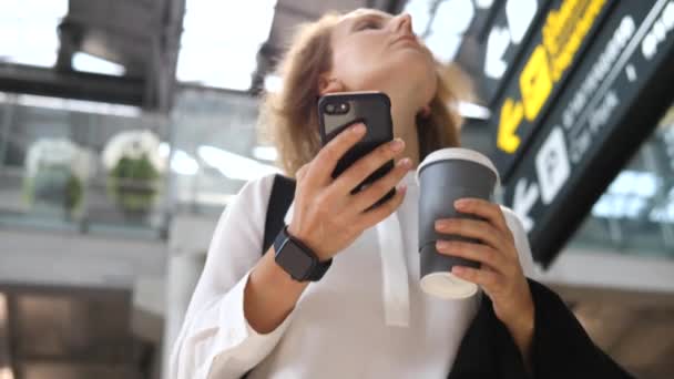 Reistechnologie concept. Vrouw met behulp van mobiele telefoon op de luchthaven in zakenreis. — Stockvideo