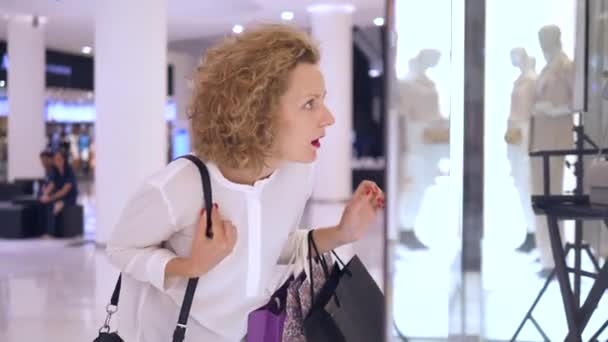 Jonge vrouwelijke klant op zoek naar etalage Winkelen voor kleding — Stockvideo