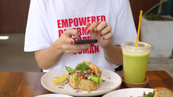 Divatos Stílusos Nő Fényképez Egészséges Élelmiszer Okostelefon Bistro. — Stock videók