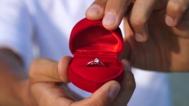 Um homem a fazer uma proposta de casamento. Fechar as mãos com caixa de anel de casamento . — Vídeo de Stock