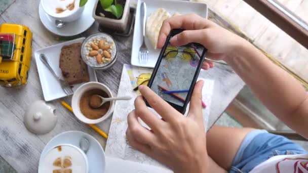 Mãos femininas tirando fotos de leigos planos criativos com alimentos usando telefone inteligente — Vídeo de Stock