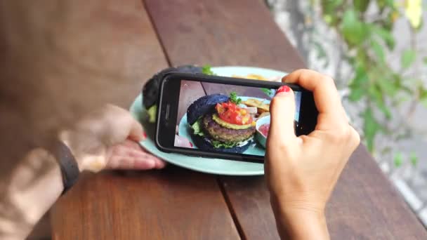 Vrouw Hand nemen van foto van hamburger met smartphone — Stockvideo