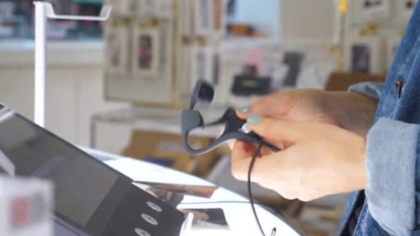 Cliente femenino eligiendo auriculares inalámbricos en la tienda — Vídeos de Stock