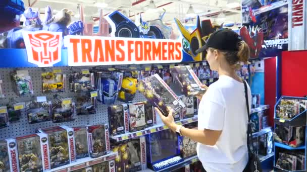 Γυναίκα πελάτης στο εμπορικό κέντρο Επιλέγοντας Transformers παιχνίδια. — Αρχείο Βίντεο