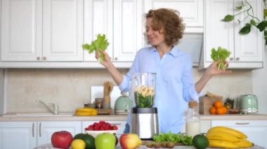 Genç Kadın Dans Ediyor ve Mutfakta Sağlıklı Meyve Smoothie Hazırlıyor