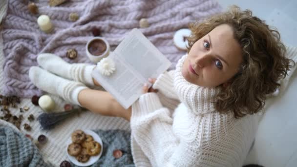 Giovane donna in maglia maglione e calze libro di lettura — Video Stock