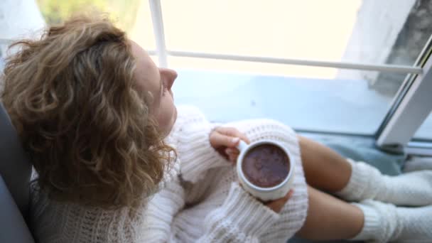 Winter Autumn Cold Season Concept (en inglés). Chica en ropa de punto con la taza por la ventana . — Vídeo de stock