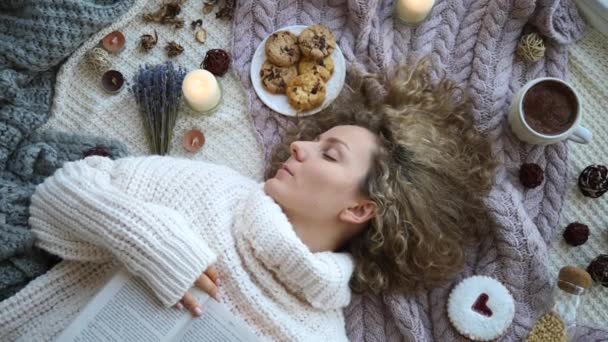 Winterferienkonzept. Mädchen im Strickpullover auf dem Bett liegend — Stockvideo