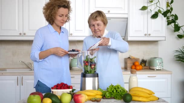 Torunu büyükannesiyle Mutfakta Smoothie pişiriyor. — Stok video