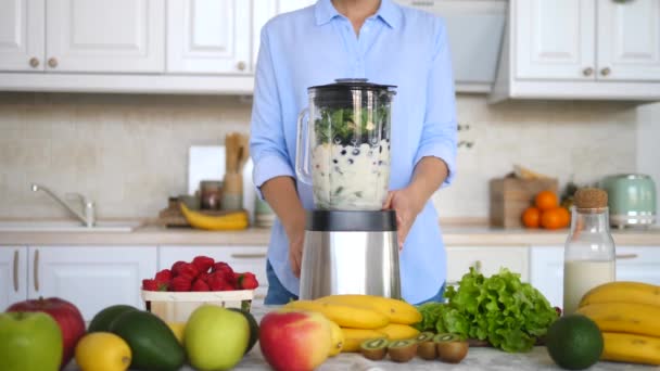 Mujer preparando batido saludable en la cocina. Concepto de dieta saludable . — Vídeo de stock