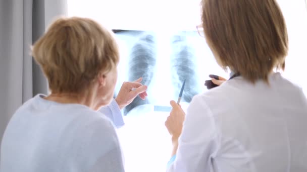 Medico che spiega i risultati delle radiografie al paziente anziano — Video Stock