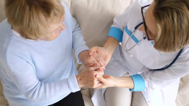 Ανώτερη γυναίκα που κρατιέται χέρι με τον γιατρό. Φροντίδα ηλικιωμένων. — Αρχείο Βίντεο