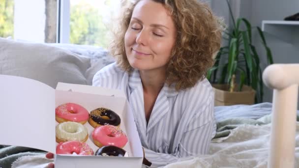 Jovem loira mulher desejando donuts deitado na cama — Vídeo de Stock