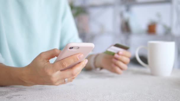 Online-Zahlung. Frau hält Kreditkarte in der Hand und nutzt Smartphone für Online-Einkäufe — Stockvideo