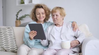 Torunum büyükanneme tablet bilgisayarın nasıl kullanılacağını öğretiyor.