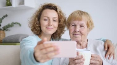 Büyükannem ve torunum akıllı telefondan fotoğraf çekiyorlar.