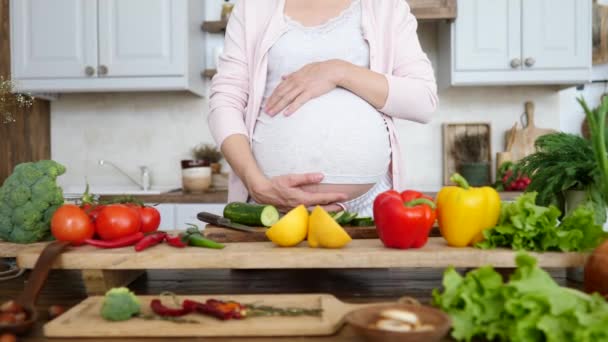Беременная женщина готовит здоровую пищу дома на кухне . — стоковое видео