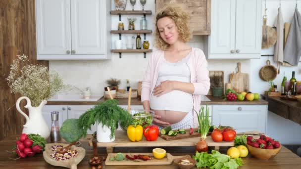 Těhotná žena vaření zdravé jídlo v kuchyni. Těhotenství Dieta a výživa koncepce. — Stock video