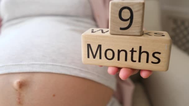 Zwangere vrouw met inscriptie van 9 maanden — Stockvideo