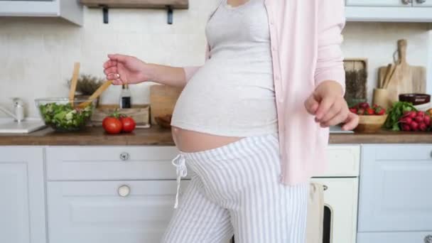 Nahaufnahme einer schwangeren Frau beim Bauchtanz zu Hause in der Küche — Stockvideo