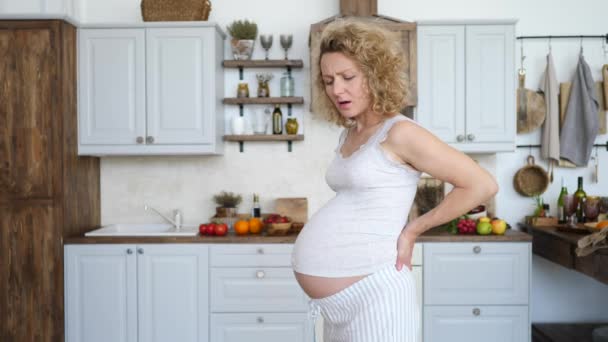 Embarazada mujer sufriendo de dolor de espalda y sosteniendo su espalda — Vídeos de Stock