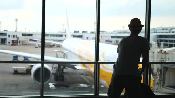 Человек путешественник с рюкзаком ждет рейс в аэропорту — стоковое видео