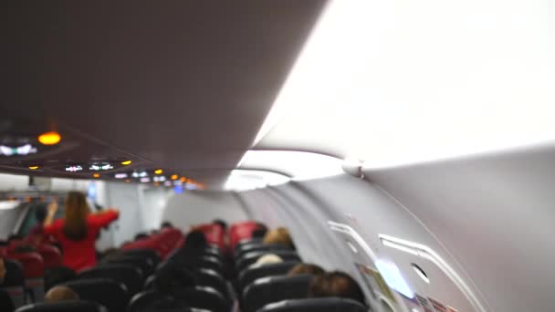 Légkondicionálós repülőgép belseje, utasok az üléseken és stewardess — Stock videók