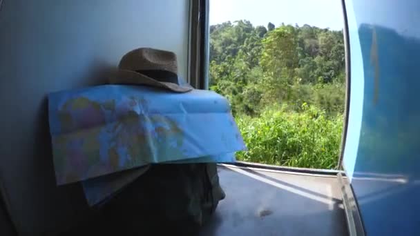 Mochila de los viajeros, mapa y sombrero de paja en el tren — Vídeos de Stock