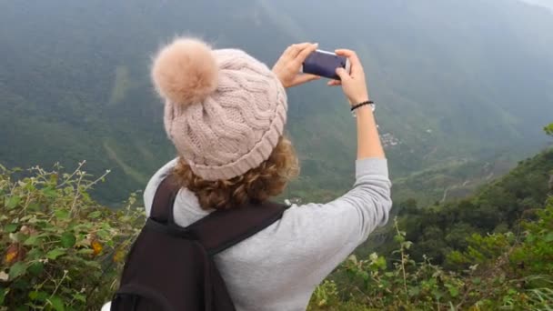 Mujer excursionista tomando fotos con Smartphone en la cima de la montaña — Vídeo de stock