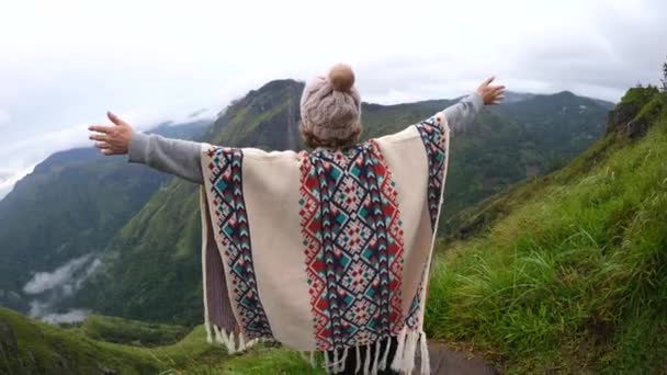 Heja kvinna vandrare i Poncho öppna armar vid Mountain Peak — Stockvideo