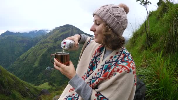 Túrázó nő kitöltése tea termosz a hegyekben — Stock videók