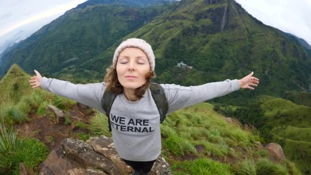 Utazó Túrázó nő karokkal kinyújtott hegytetőn — Stock videók