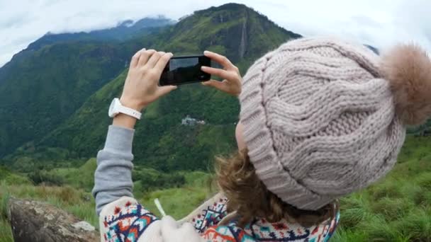 Senderista femenina tomando fotos con Smartphone en la cima de la montaña — Vídeos de Stock