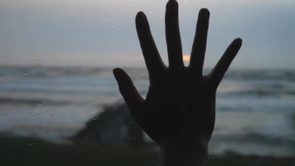 Mão feminina na janela que passa pelo mar no transporte no por do sol — Vídeo de Stock