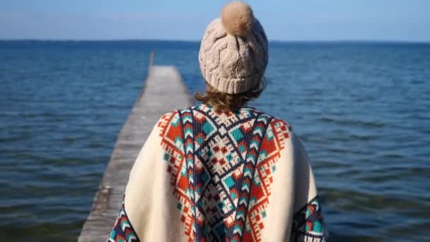 Mujer joven caminando en muelle de madera disfrutando de la vista al mar — Vídeos de Stock