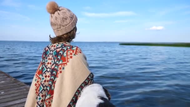 Mujer sentada con perro en muelle disfrutando de la naturaleza y el sol — Vídeos de Stock