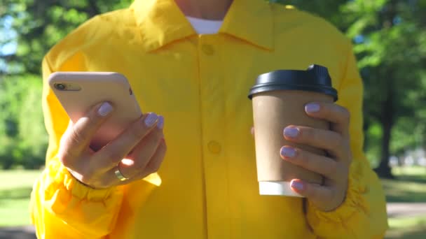 Женские руки со смартфоном и одноразовый кофе Кубок идти — стоковое видео