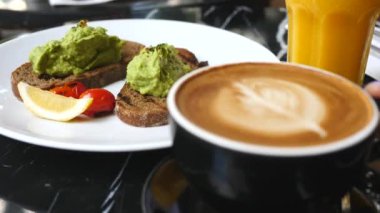 Kahvaltıda Avokado tostları ve Koyu Çavdar Ekmeği ve Kahve Lattesi.