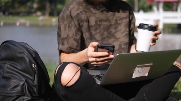 Mulher usando smartphone e laptop ao ar livre com taça de café Takeaway — Vídeo de Stock