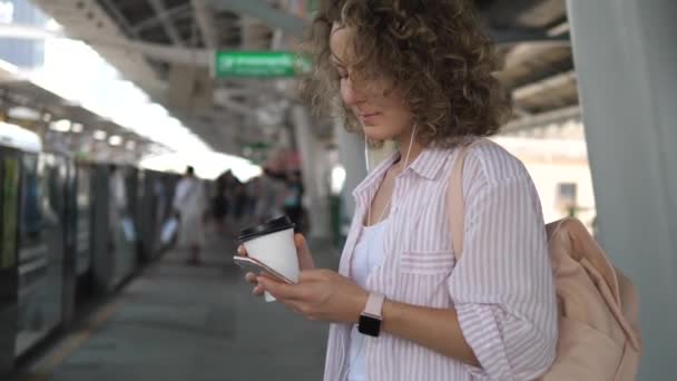 Pendlerin benutzt Handy beim Warten auf Zug — Stockvideo