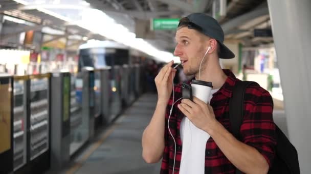 Homme parlant sur le téléphone portable dans les écouteurs sur la plate-forme — Video