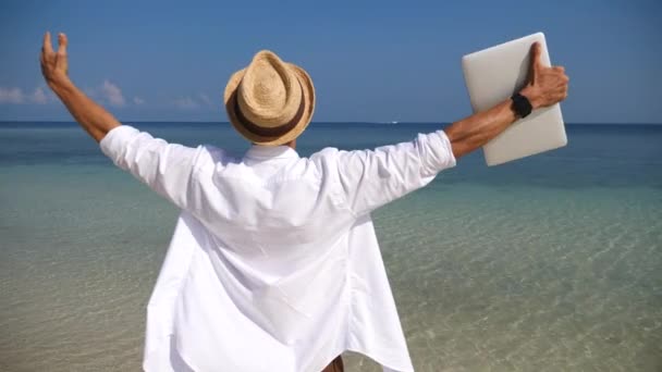 Biznes Man z ramionami wyciągnięte Holding Laptop korzystających z wakacji na plaży — Wideo stockowe